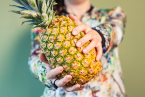 Pineapple being held between hands